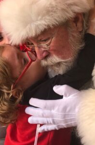 santa getting a kiss from a young boy